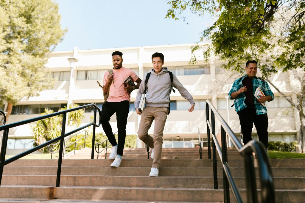 A group of 3 people walking down the stairs.